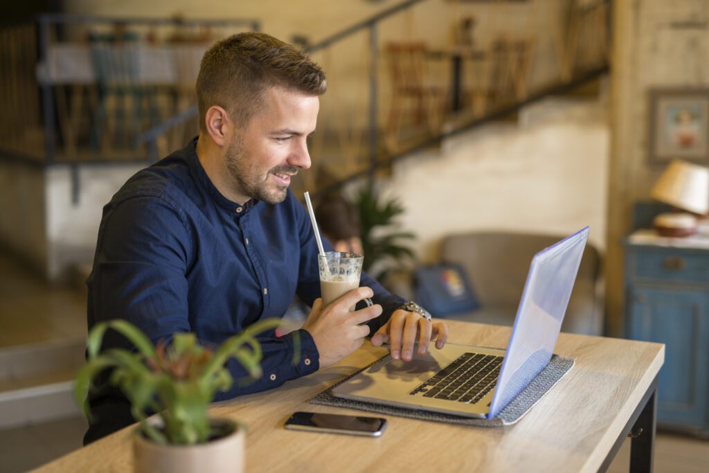 Smiling young professional working remotely on laptop